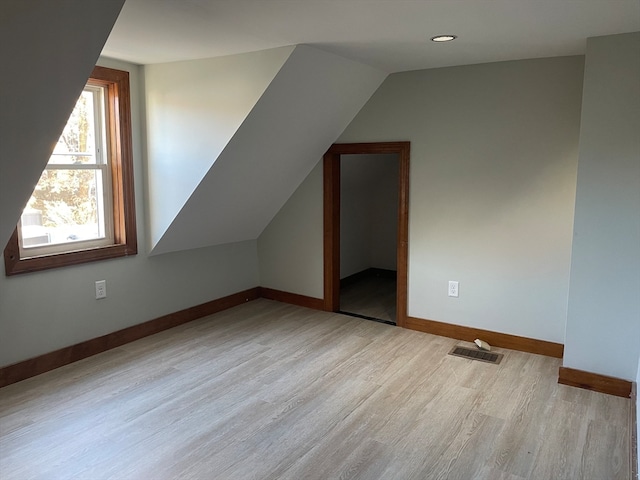 additional living space featuring lofted ceiling and light hardwood / wood-style flooring