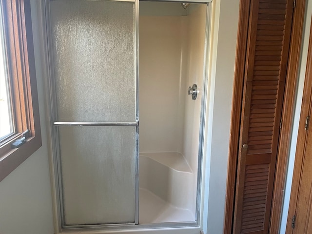 bathroom with a shower with door