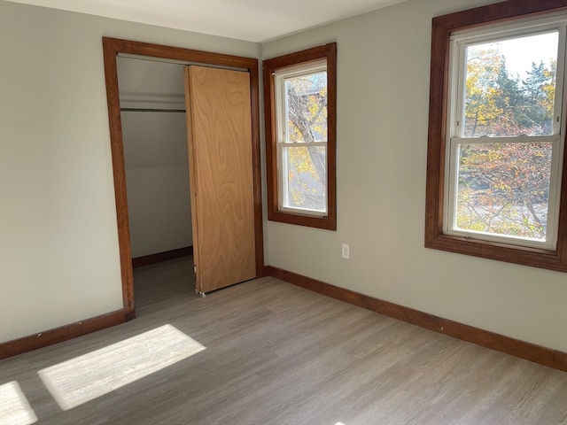 unfurnished bedroom featuring a closet and light wood-type flooring