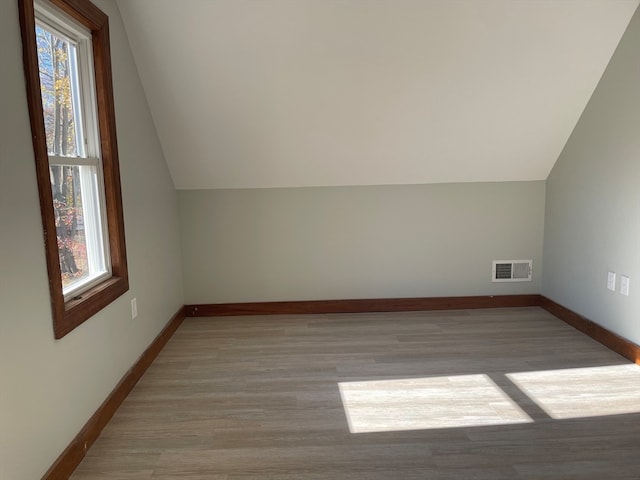 bonus room with light hardwood / wood-style flooring and vaulted ceiling