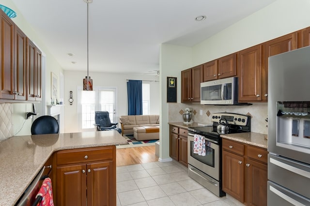 kitchen with pendant lighting, light hardwood / wood-style floors, decorative backsplash, appliances with stainless steel finishes, and ceiling fan