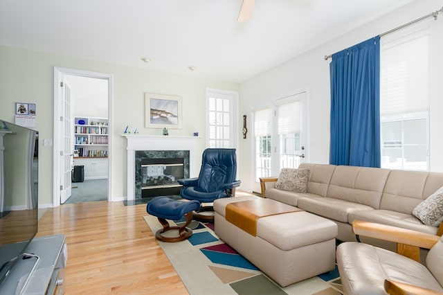 living room with ceiling fan, hardwood / wood-style floors, and a high end fireplace