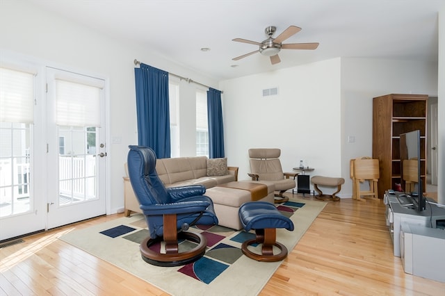 living room featuring light hardwood / wood-style floors, ceiling fan, and a wealth of natural light