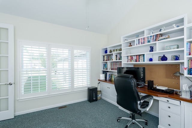 carpeted home office featuring vaulted ceiling