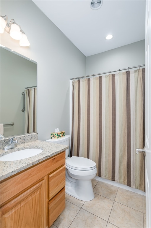 bathroom featuring a shower with shower curtain, tile patterned flooring, vanity, and toilet