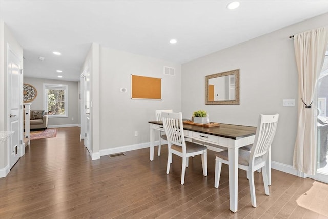 dining area featuring baseboards, wood finished floors, and visible vents