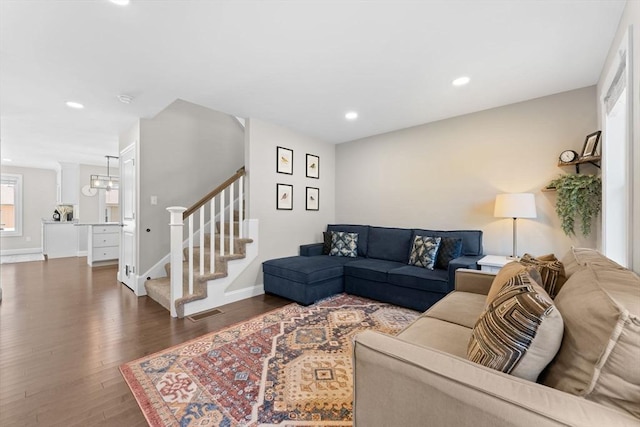 living room featuring wood finished floors, stairway, baseboards, a notable chandelier, and recessed lighting