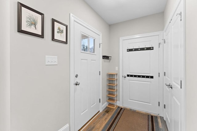 entryway featuring baseboards and dark wood finished floors