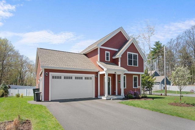 view of front of home featuring roof with shingles, a front yard, a garage, fence, and aphalt driveway