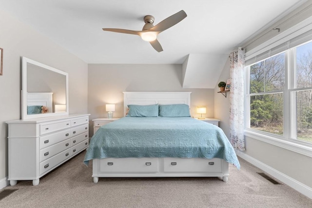 bedroom with baseboards, a ceiling fan, light colored carpet, and visible vents