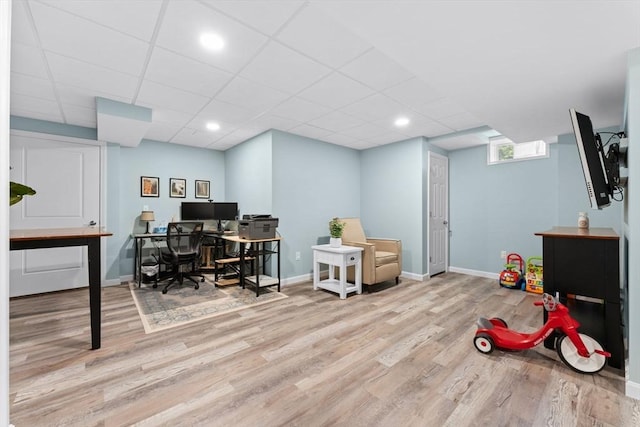 office area featuring a paneled ceiling, baseboards, and wood finished floors