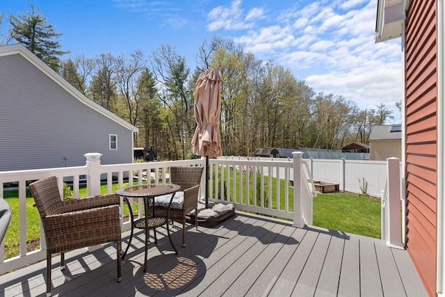 wooden deck featuring a yard and fence