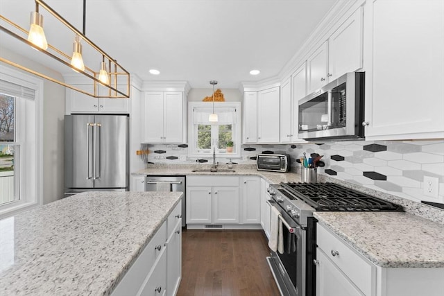 kitchen with a sink, white cabinetry, recessed lighting, high end appliances, and dark wood-style floors
