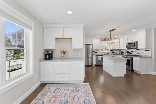 kitchen with white cabinetry, appliances with stainless steel finishes, tasteful backsplash, and dark wood-type flooring