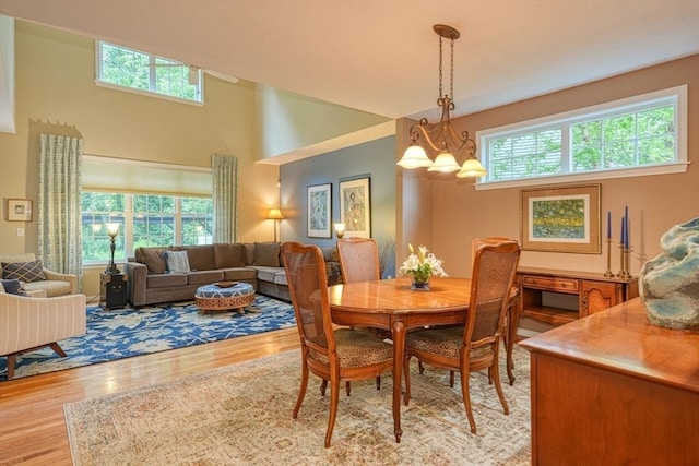 44 Stevens Rd Unit 44, Hudson, MA 01749 - dining area with light wood-style floors, a chandelier, and a towering ceiling