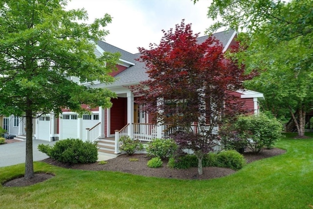 44 Stevens Rd Unit 44, Hudson, MA 01749 - obstructed view of property featuring a front yard, a garage, covered porch, a shingled roof, and concrete driveway