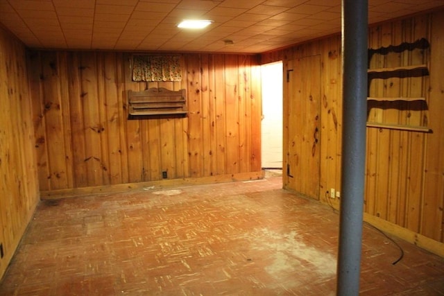 finished basement featuring wooden walls