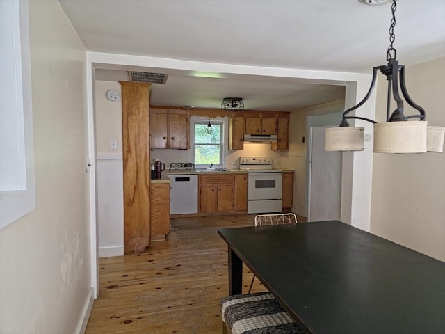 48 Sofia Rd, Stoughton, MA 02072 - kitchen featuring white appliances, under cabinet range hood, brown cabinetry, and light wood-type flooring