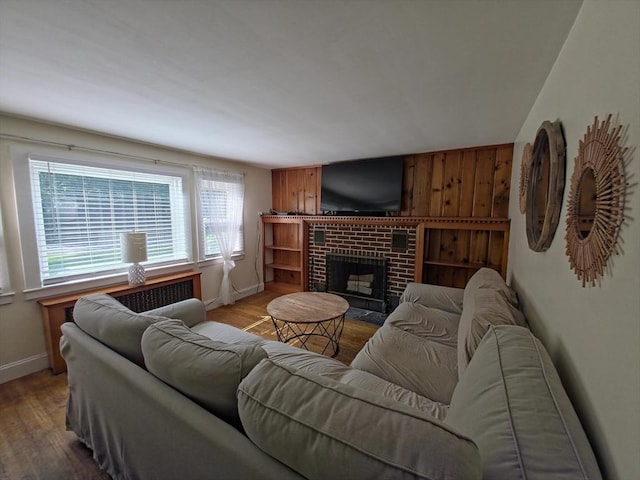 48 Sofia Rd, Stoughton, MA 02072 - living area featuring wood finished floors, a fireplace, radiator, and wooden walls