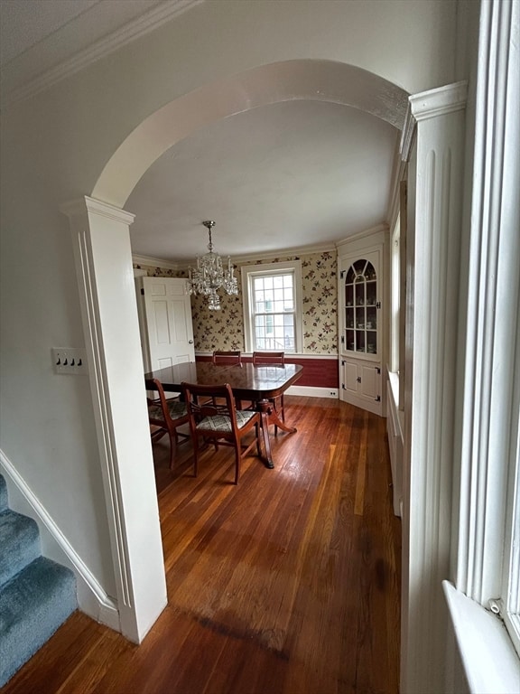 dining room with an inviting chandelier, ornamental molding, and dark hardwood / wood-style floors