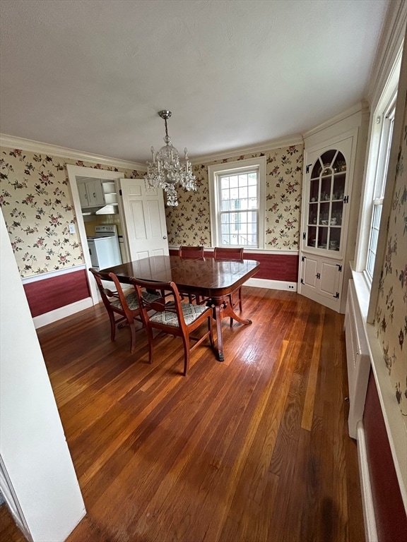 dining area featuring ornamental molding, a chandelier, and dark hardwood / wood-style flooring