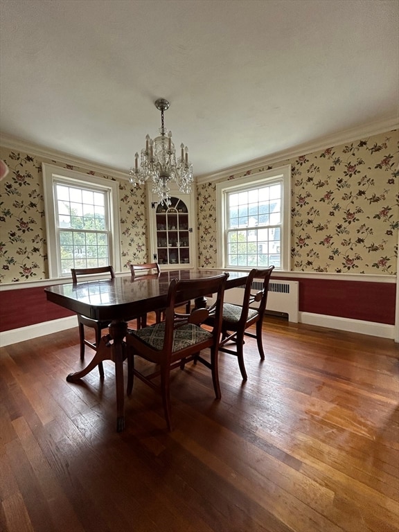 dining space with ornamental molding, plenty of natural light, and dark hardwood / wood-style flooring