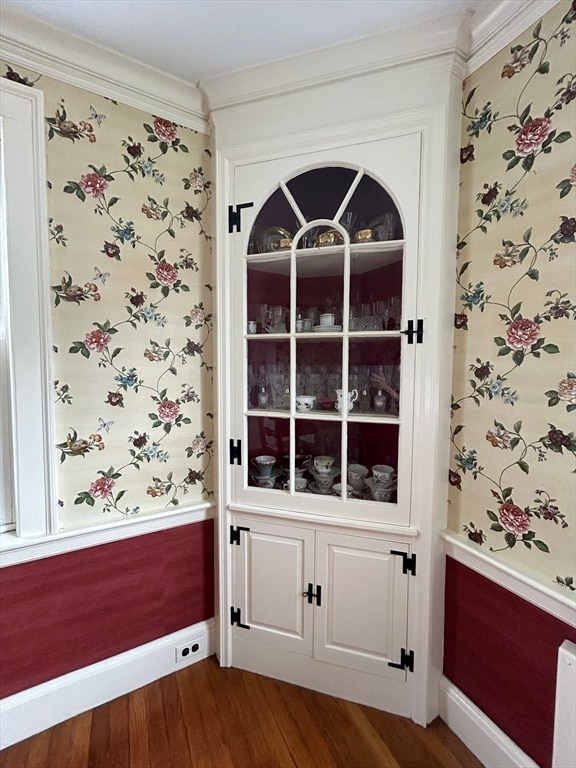 doorway with dark hardwood / wood-style floors and crown molding