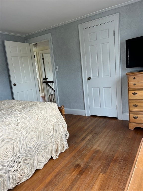 bedroom featuring dark hardwood / wood-style floors and crown molding