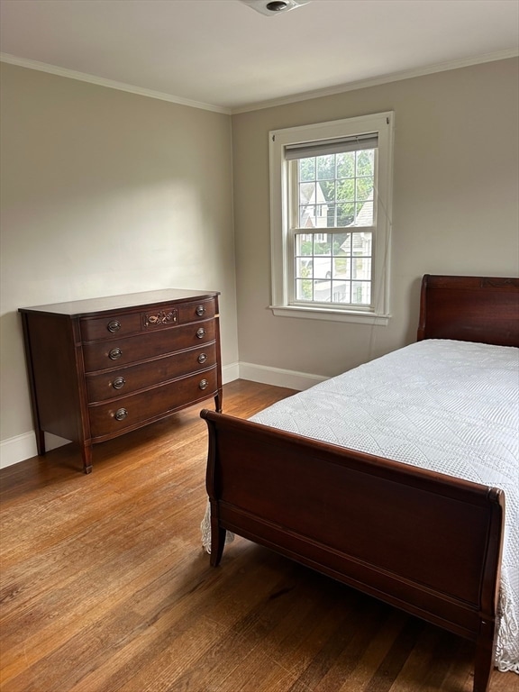 bedroom with crown molding and light hardwood / wood-style flooring