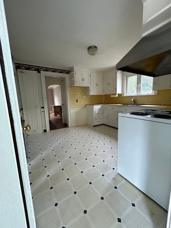 kitchen with sink, white cabinetry, backsplash, exhaust hood, and white range oven