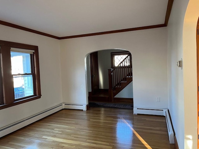 unfurnished room featuring wood-type flooring, ornamental molding, and a baseboard radiator