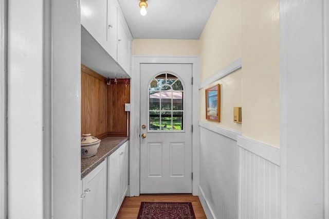 68 Ingersoll Grv, Springfield, MA 01109 - doorway to outside featuring light wood-style floors and a wainscoted wall