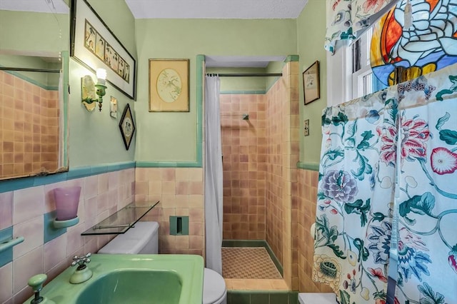 68 Ingersoll Grv, Springfield, MA 01109 - bathroom with wainscoting, toilet, tile walls, a sink, and a stall shower