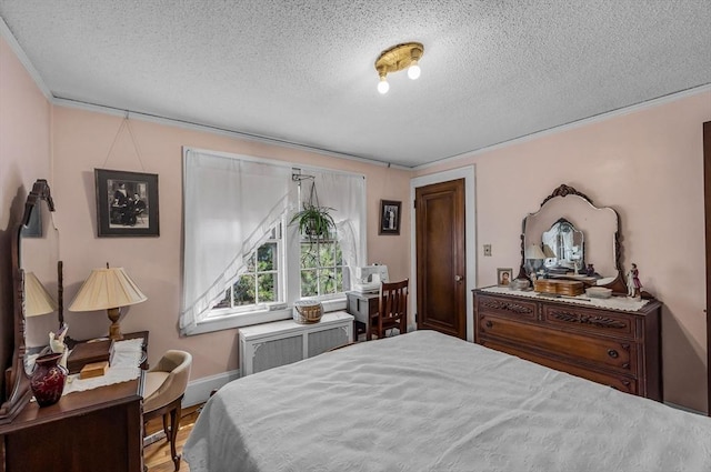 68 Ingersoll Grv, Springfield, MA 01109 - bedroom with wood finished floors, a textured ceiling, crown molding, and radiator heating unit