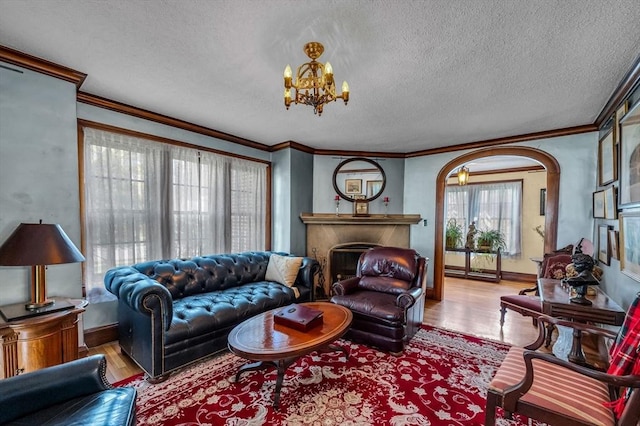 68 Ingersoll Grv, Springfield, MA 01109 - living room featuring crown molding, a fireplace, a textured ceiling, a chandelier, and wood finished floors