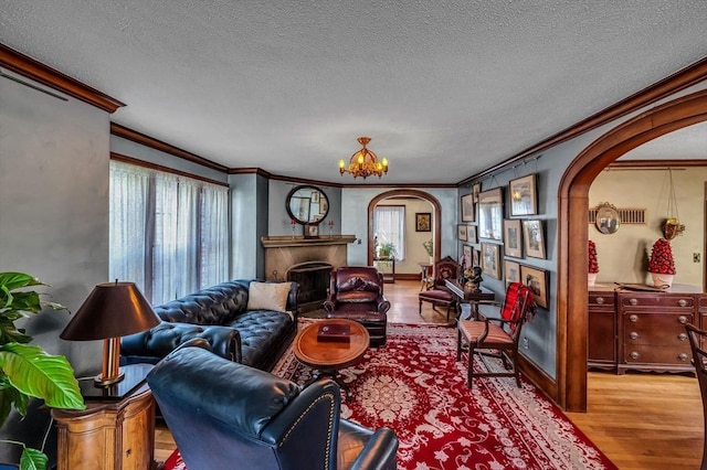 68 Ingersoll Grv, Springfield, MA 01109 - living room with crown molding, arched walkways, wood finished floors, and a fireplace