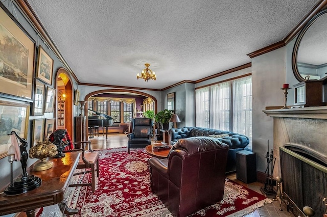 68 Ingersoll Grv, Springfield, MA 01109 - living room with ornamental molding, a textured ceiling, arched walkways, and a fireplace