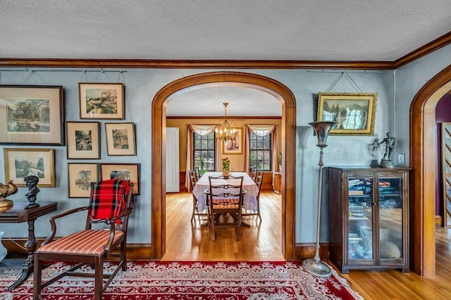68 Ingersoll Grv, Springfield, MA 01109 - dining space featuring crown molding, arched walkways, a textured ceiling, and wood finished floors