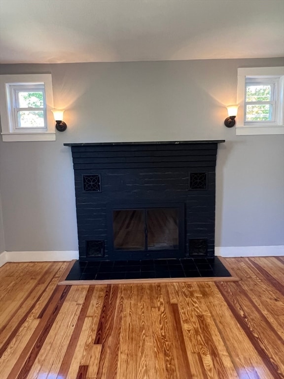 details featuring hardwood / wood-style floors and a tile fireplace