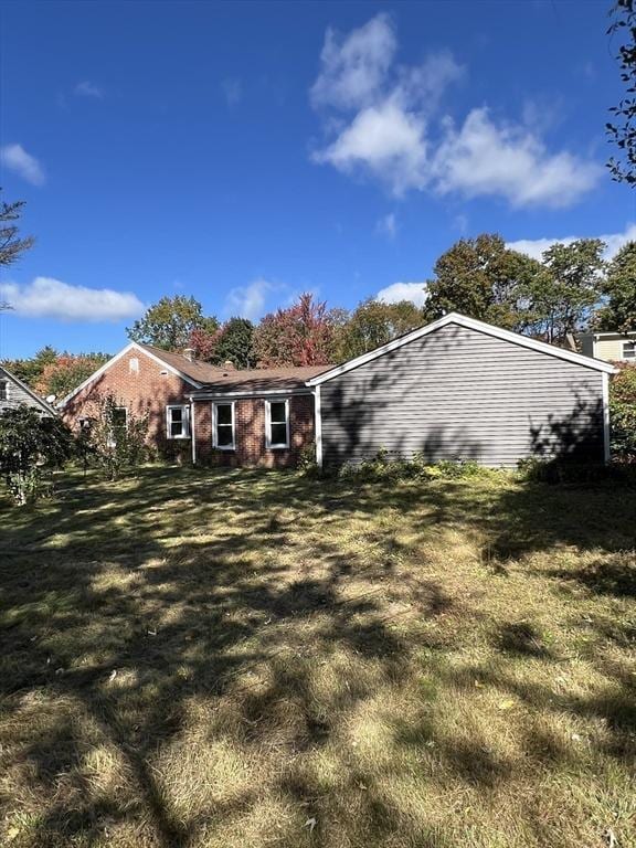 rear view of property featuring a lawn