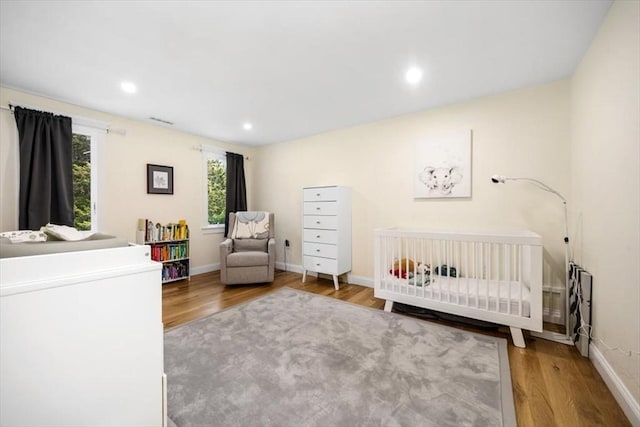 4 Cushing St, Hingham, MA 02043 - bedroom featuring wood finished floors, a crib, baseboards, and recessed lighting