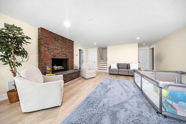 4 Cushing St, Hingham, MA 02043 - living room with light wood-style flooring, stairs, a brick fireplace, and recessed lighting