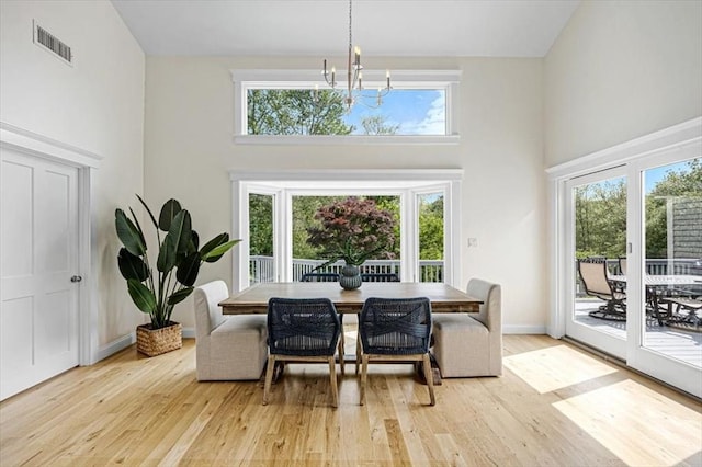 4 Cushing St, Hingham, MA 02043 - dining room featuring a chandelier, a towering ceiling, and light wood-type flooring