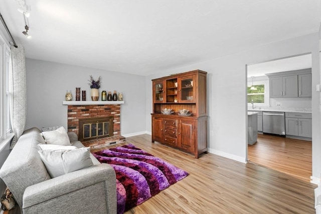 18 Buena Vis Unit 18, Franklin, MA 02038 - living area featuring light wood finished floors, a brick fireplace, and baseboards