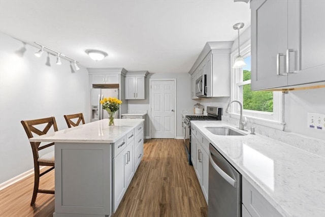 18 Buena Vis Unit 18, Franklin, MA 02038 - kitchen with appliances with stainless steel finishes, a sink, a kitchen bar, light stone countertops, and gray cabinetry