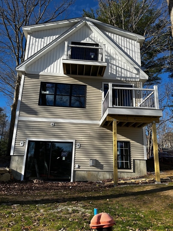 back of house featuring a balcony, cooling unit, and board and batten siding