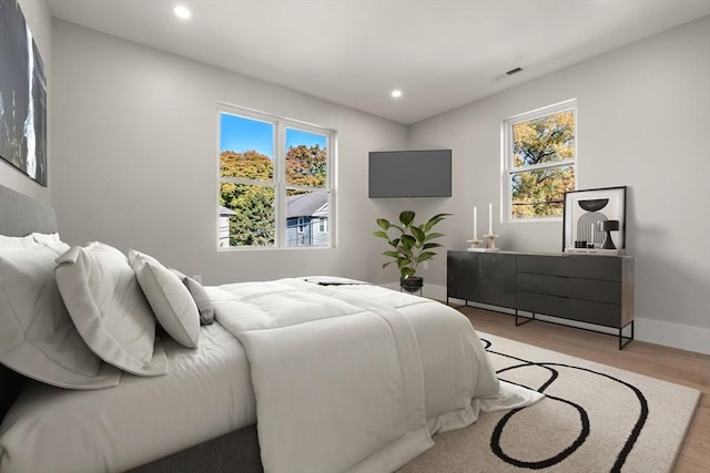 bedroom with multiple windows, visible vents, light wood-style floors, and recessed lighting