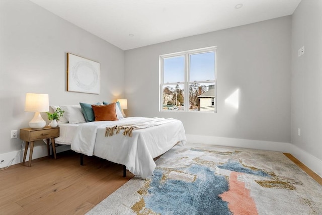bedroom with baseboards and wood finished floors