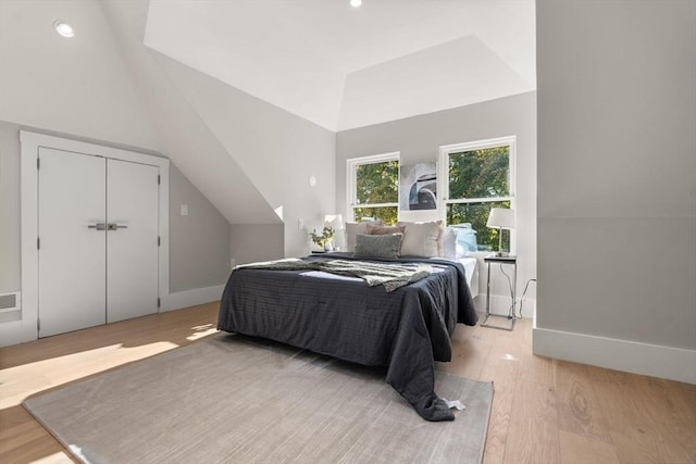 bedroom featuring baseboards, vaulted ceiling, and wood finished floors