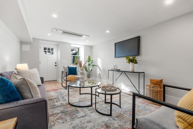 living room with recessed lighting, baseboards, and wood finished floors